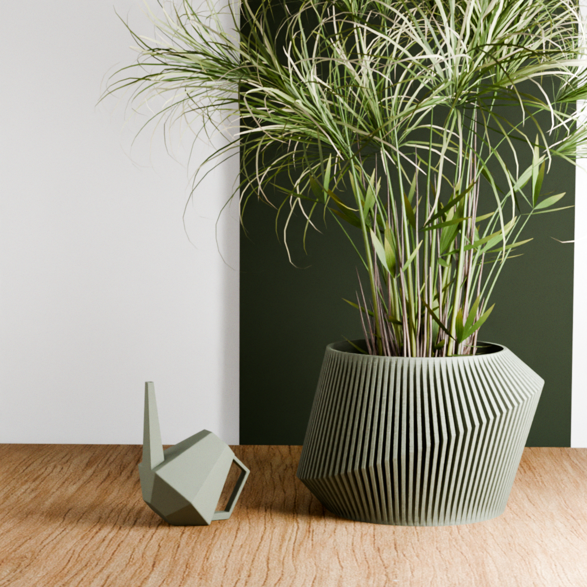 Modern geometric planter with tall green ornamental grass and a matching angular watering can on a wooden surface, against a minimalist two-tone wall.