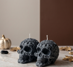Dark Gray skull-shaped candles on a neutral background with decorative elements.