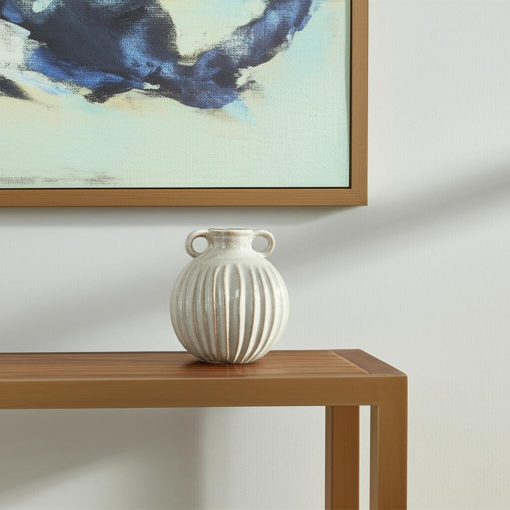 Gray vase on a wooden table with abstract art in the background
