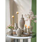 Decorative table setting with vases, candles, and flowers in a home interior.