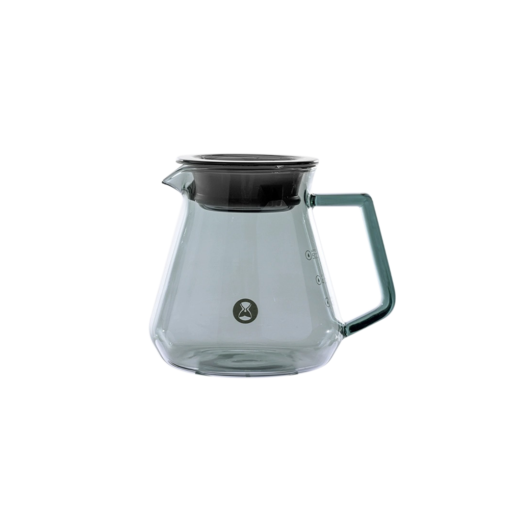 Clear glass coffee server with black lid on a white background