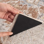 Black triangular rug pad held over a textured rug
