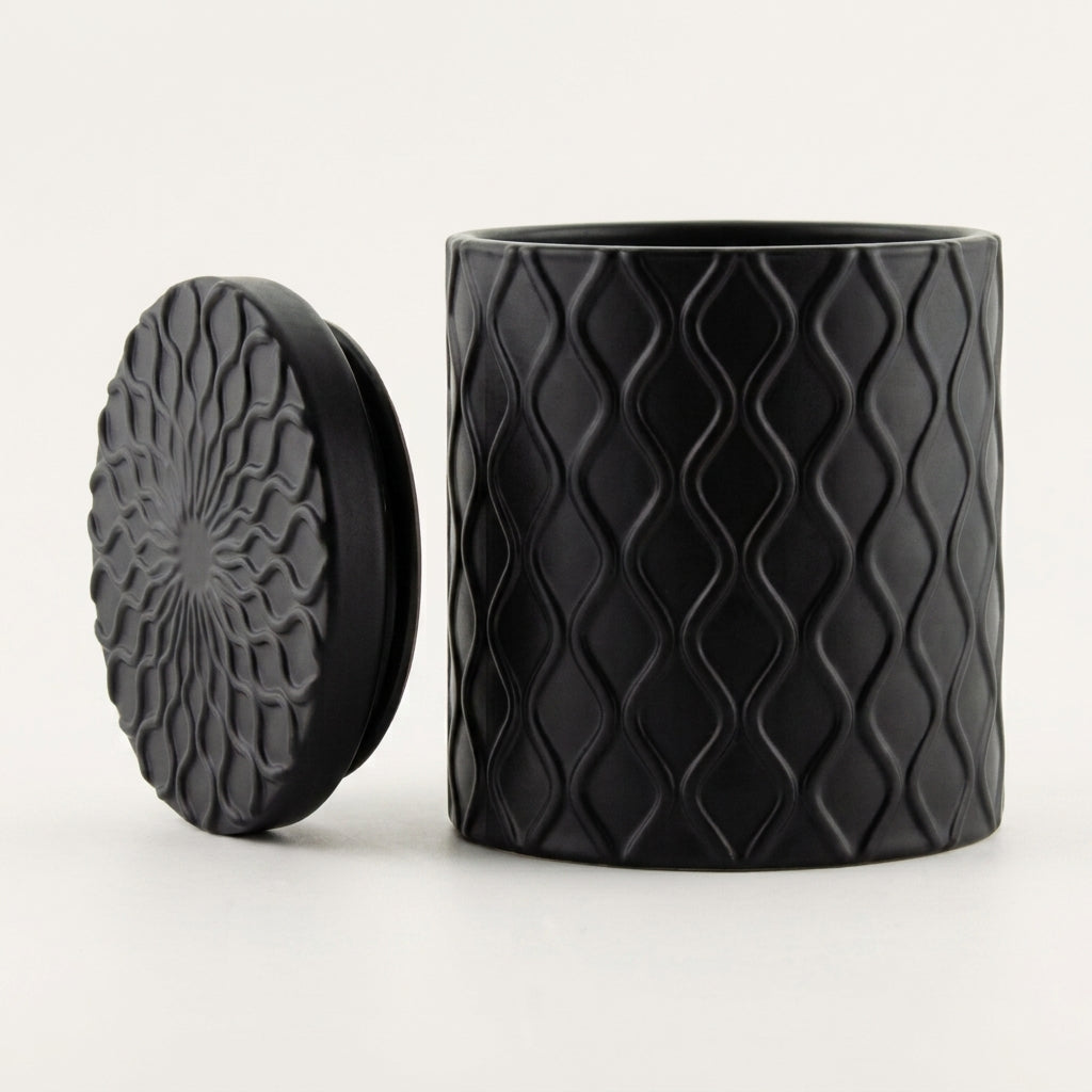Forbidden Masculine Scent — Matte Black Textured Ceramic Candle with Lid, shown on a clean white background. The container features a raised wavy diamond pattern, and the lid displays a matching embossed floral or sunburst design.