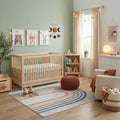Nursery room with wooden crib, books, and decorative elements around the Giza Contemporary Washable Multicolor Rainbow Rug