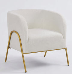 White upholstered armchair with curved backrest and gold metal legs, set against a plain light background.