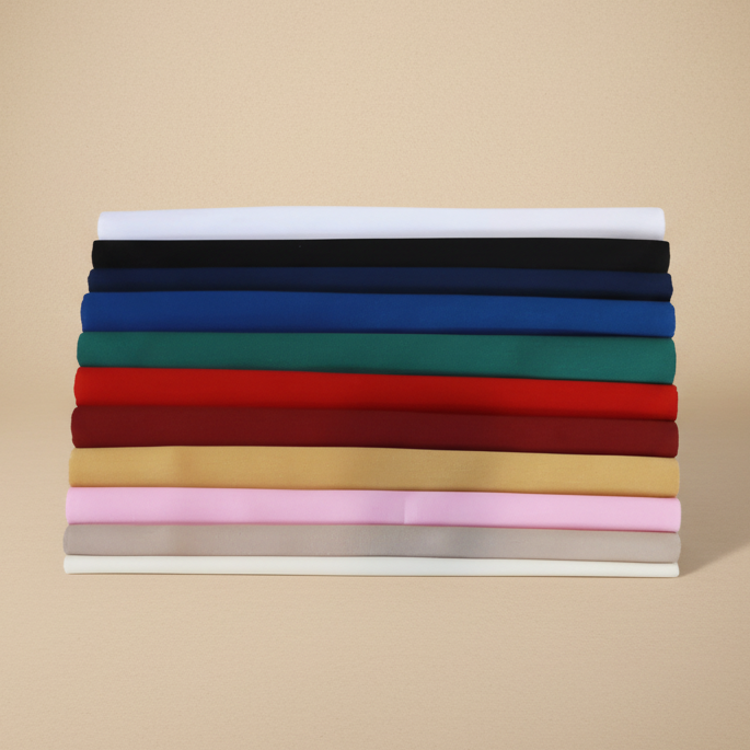 Stack of folded fabric swatches in various colors on a beige background