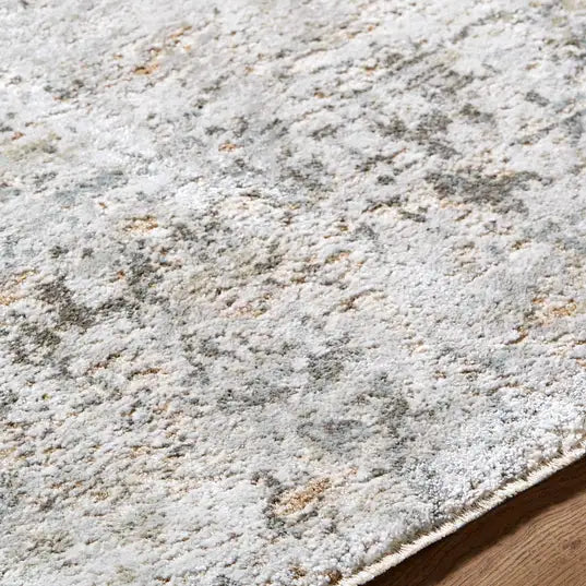 Close-up of a textured beige and brown  Meral Thick Luxe Boutique Area Rug on a wooden floor