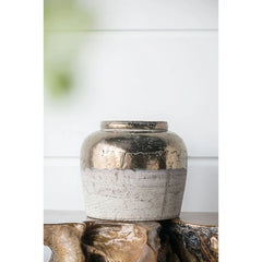 Decorative ceramic vase with metallic finish on a wooden surface