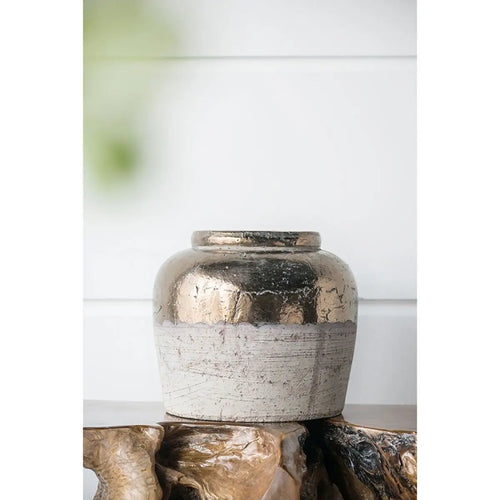 Decorative ceramic vase with metallic finish on a wooden surface