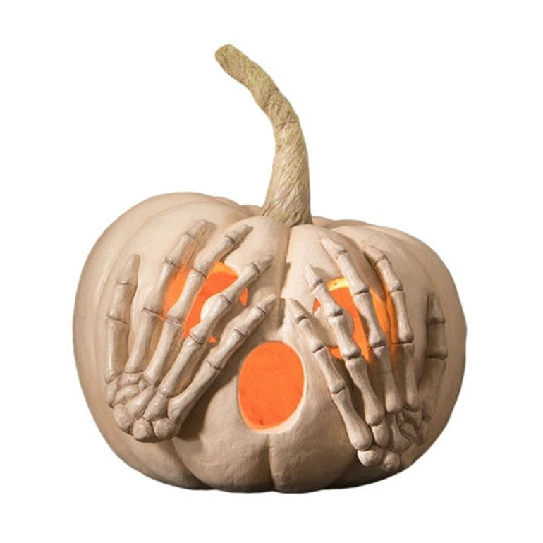 Decorative pumpkin with skeleton hands and glowing interior on a white background