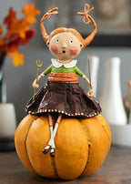 Decorative figurine of a girl with orange hair sitting on a pumpkin known as Prissy Pumpkin Eater Figurine by Lori Mitchell styled in a living area